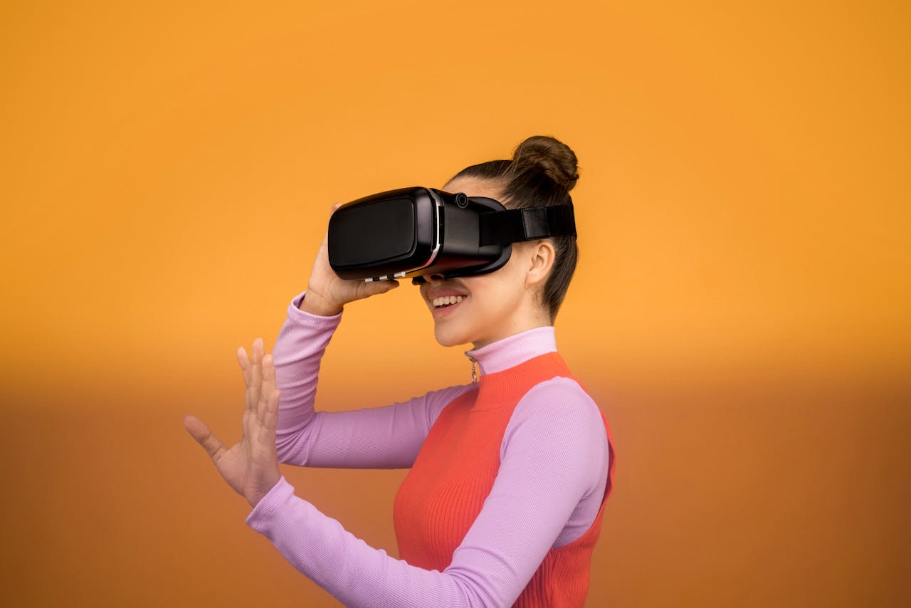 A woman smiling and interacting with a VR headset against an orange background.
